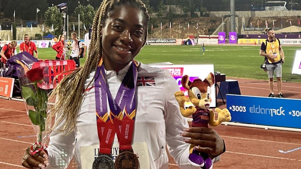 Success stands on the running track with two medals