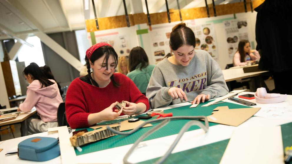 Two interior design students cutting out cardboard for their projects