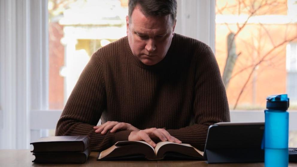 Jonathon Lord sat at a table reading a book