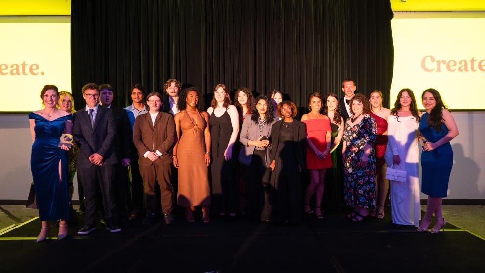 A group of students stand on the Lowry Hotel stage 