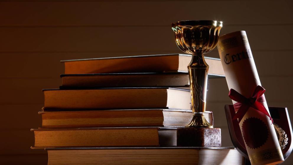 A trophy sits next to a collection of books