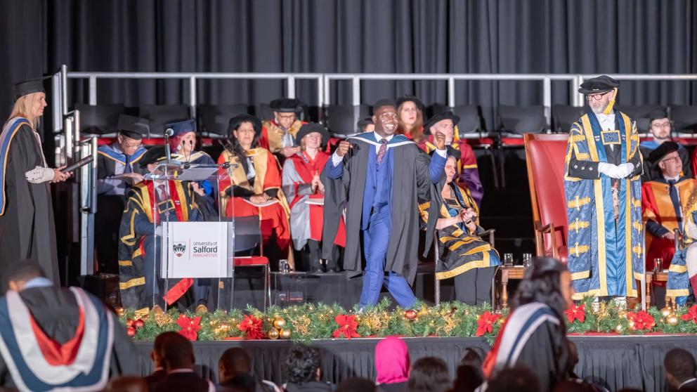 graduate crosses the graduation stage passed the Vice-Chancellor and celebrates