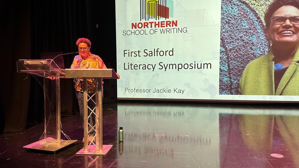 Jackie Kay speaks at a lectern at Salford Literacy Symposium