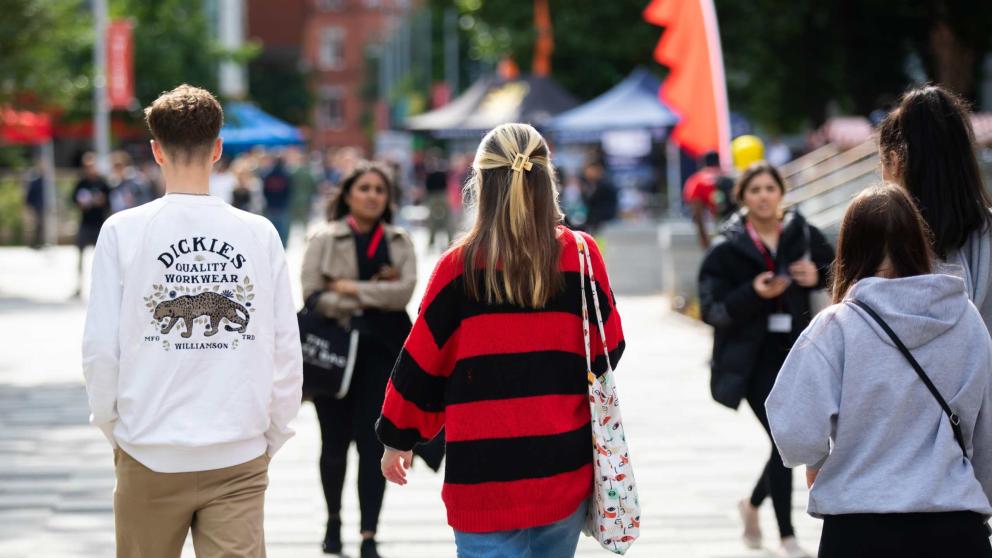 Several students walking through Peel Park Campus, University of Salford