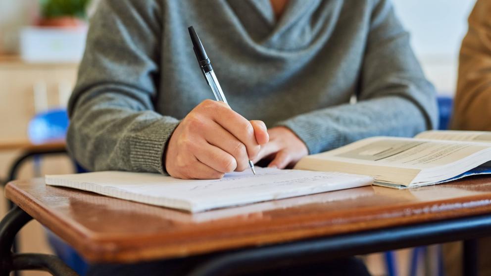 A student writes on a notepad in a lecture