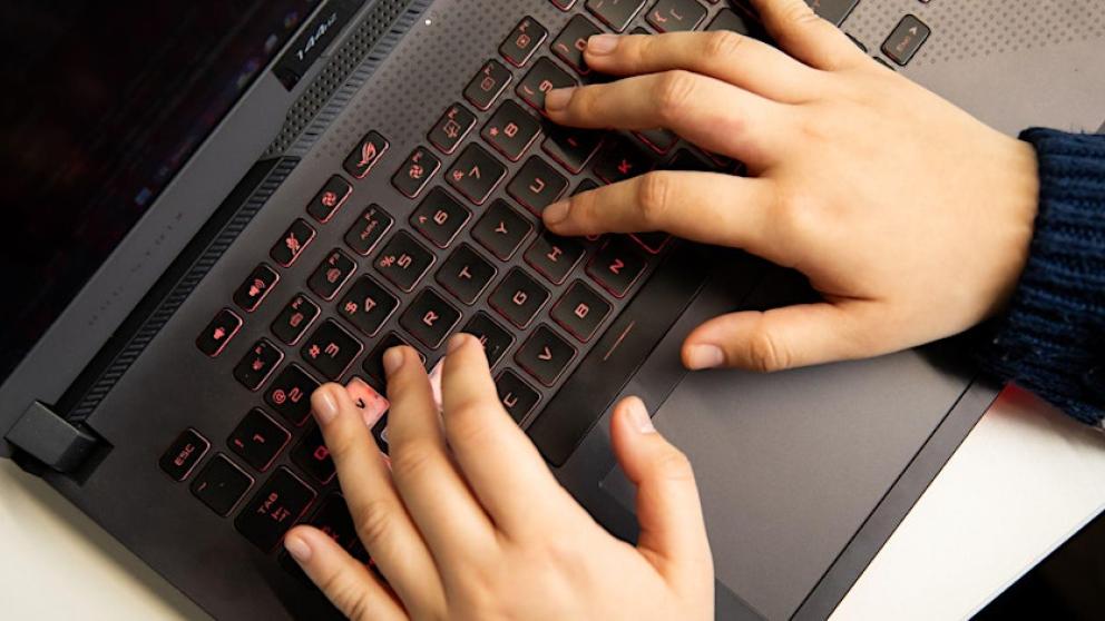 Fingers tapping on a laptop keyboard.