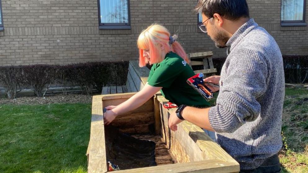 People working together to help build a planter at the Community Growing Space.