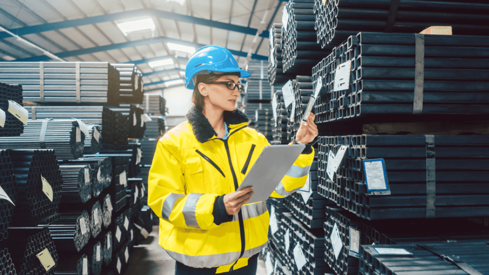 Woman reviewing stock in a steel warehouse