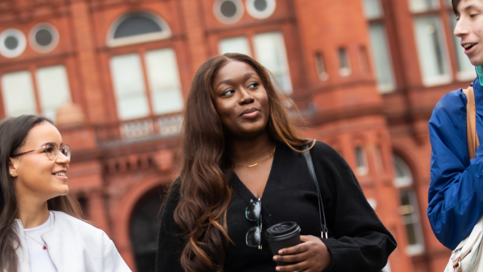 Students chatting outside the Peel Building, University of Salford