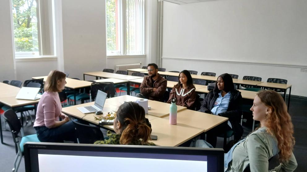 A group of people sitting around one table discussing together.