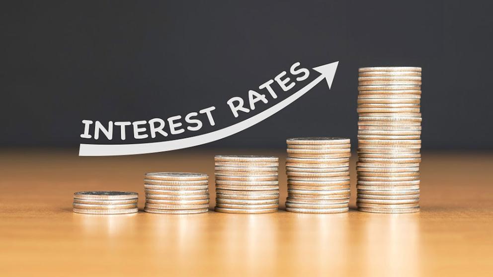 Increasing coin stacks with lettering to indicate raising interest rates