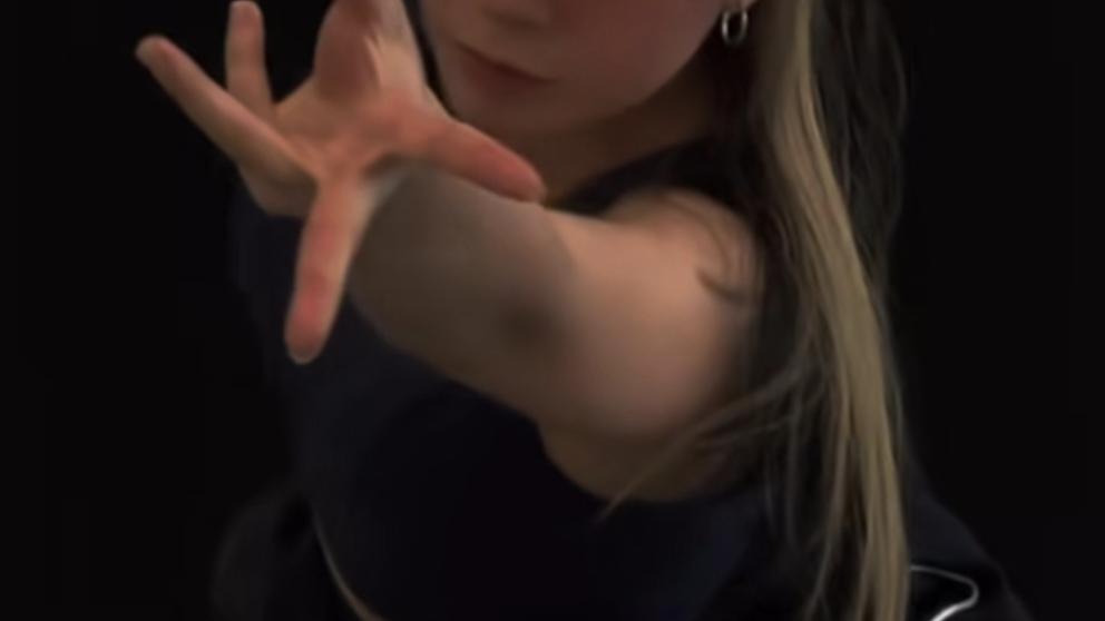 A dance student reaches out towards the camera