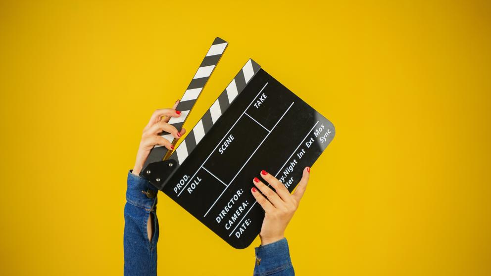 A person shuts a clapper board