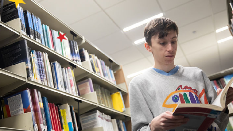 Student reading book in library
