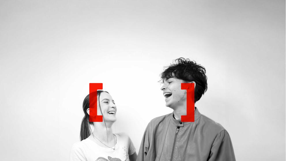 Two student friends looking at each other and laughing