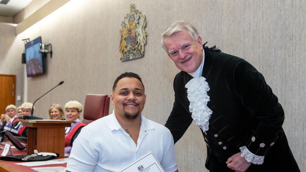 A man receiving an award from a Sherriff in a courtroom