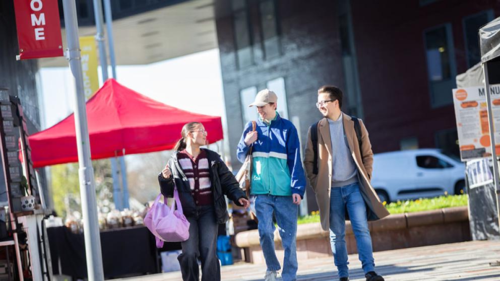 Three students walking through Chapman Square