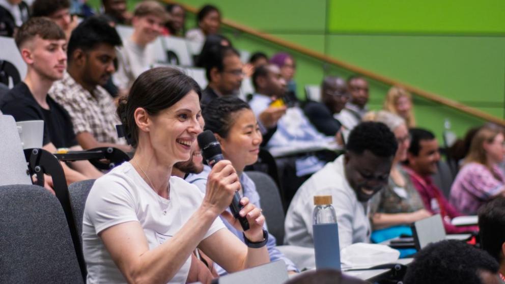 A lady clapping in the crowd at the 2025 SPARC Conference, it is set in one of the lecture halls