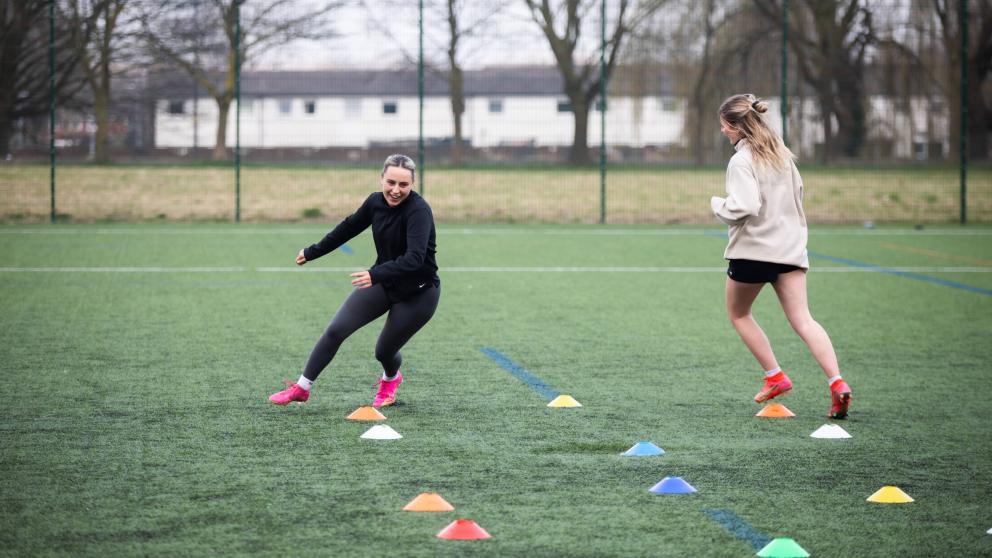 Two Students Running Around 3G Pitch