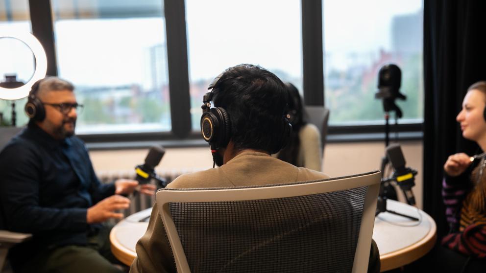 students using podcast equipment in media suite
