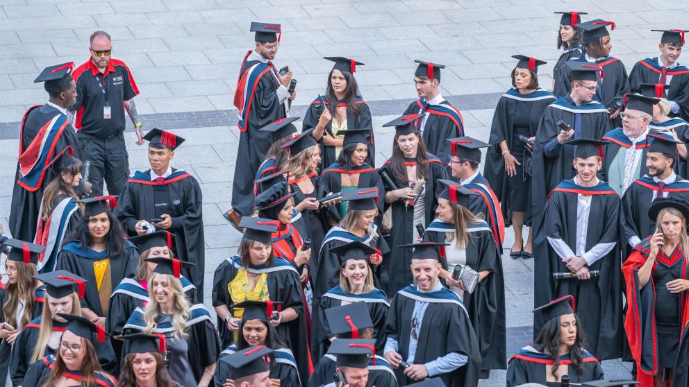 A group of graduating students stood talking after their ceremony