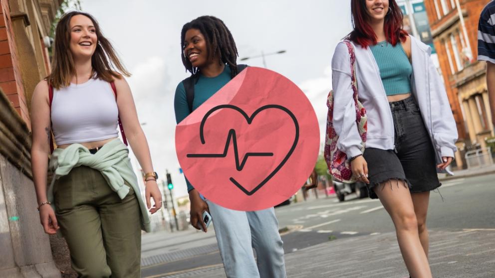 Three students walking down the street with a health sticker