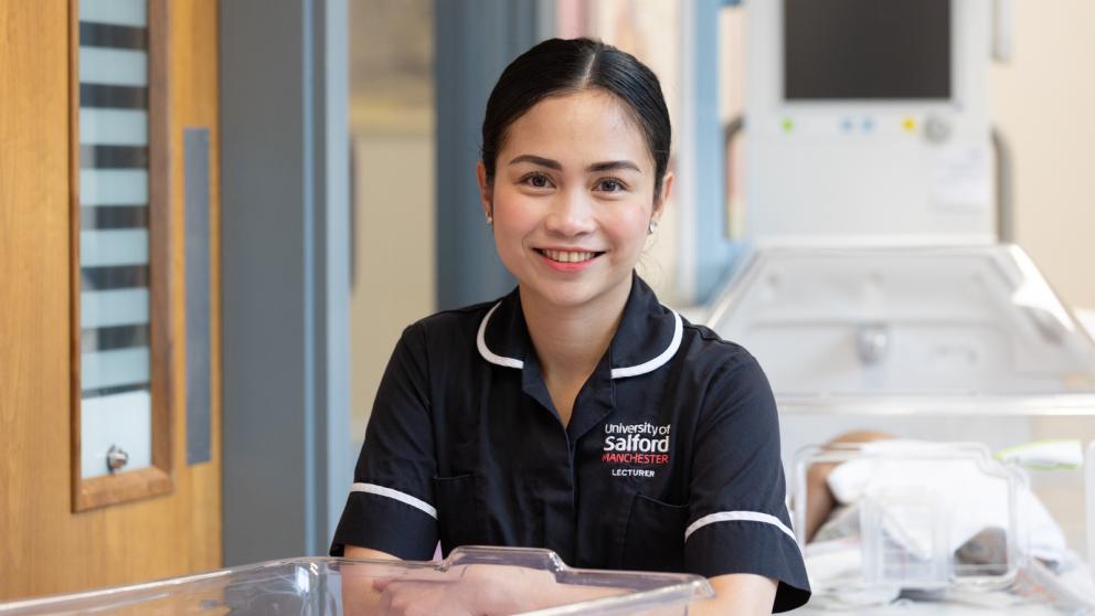 Nurse wearing a University of Salford branded uniform within the Simulation Suite, University of Salford