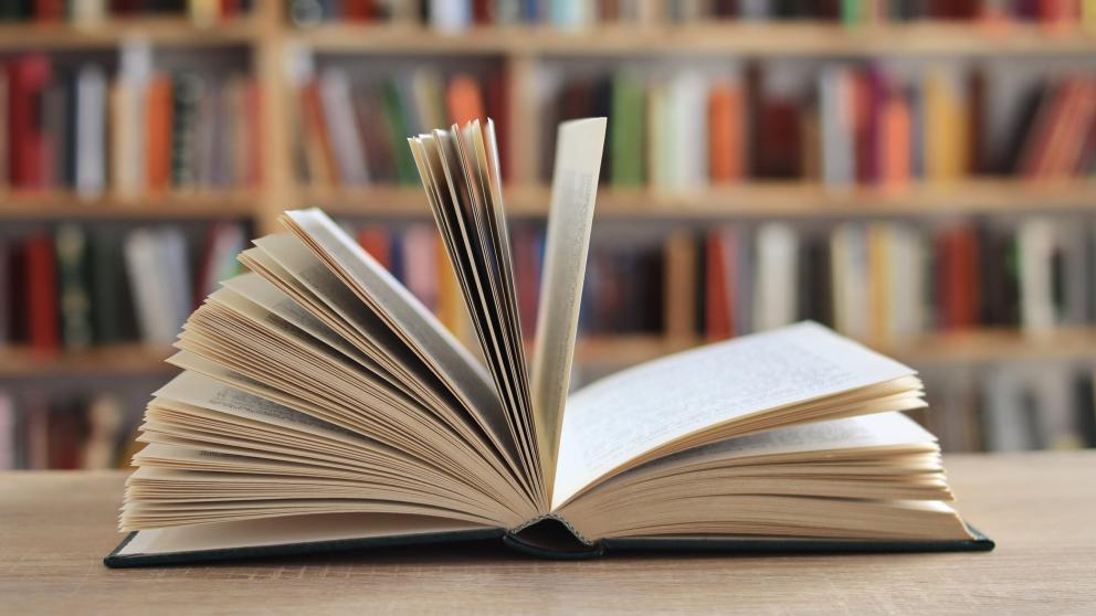 Open book in front of bookcase
