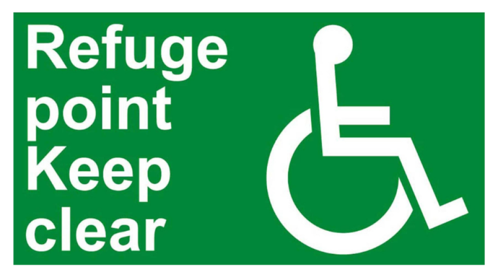 A green sign displaying text and a disability icon. Text reads: Refuge point keep clear