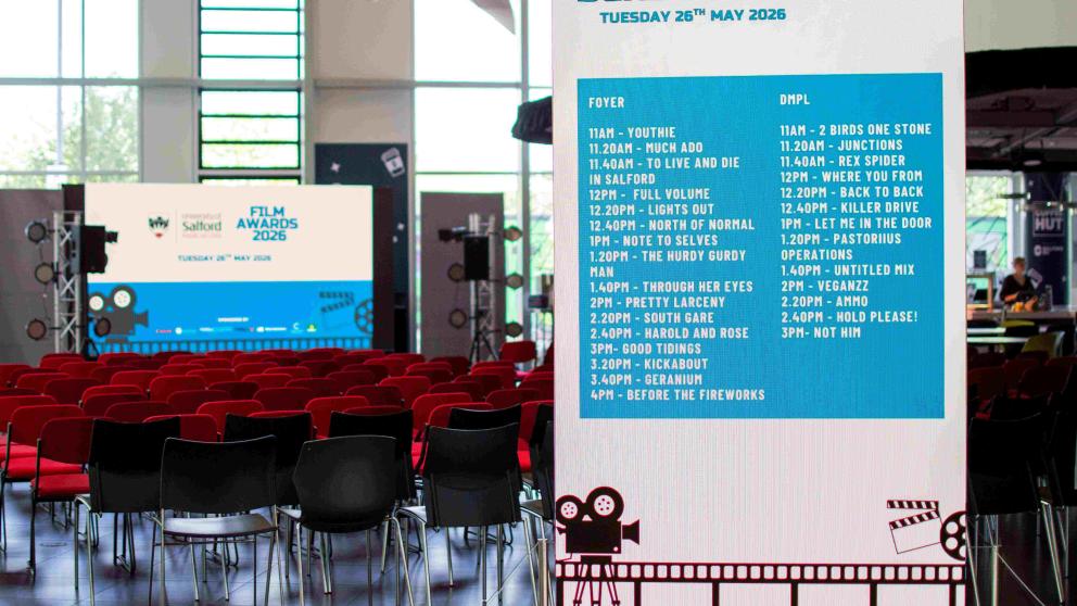 Rows of chairs set up for the Film Production Awards, with a large banner listing the screening schedule. 