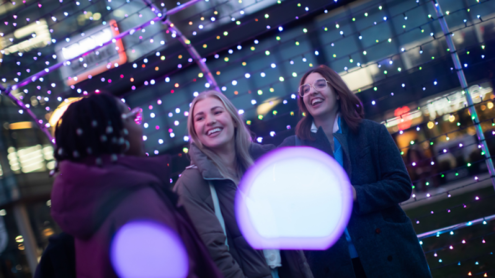 Students smiling at light show