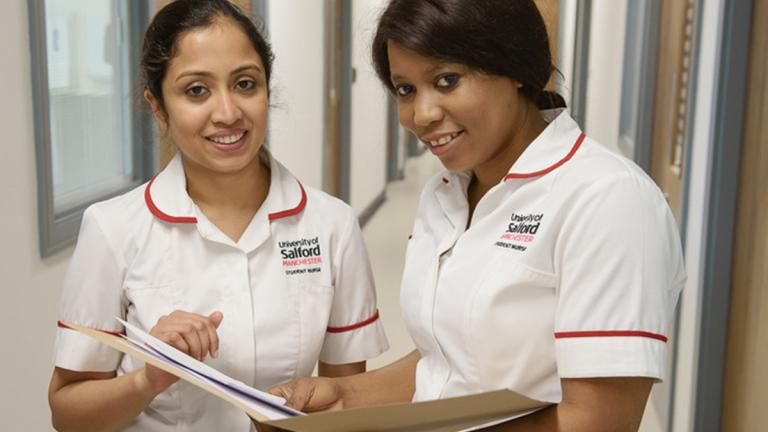 Student nurses reading patient records