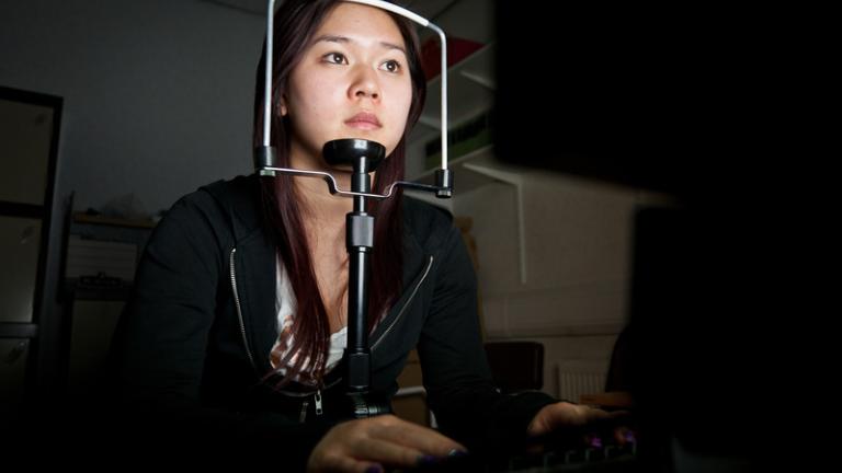Psychology student looking into a screen with chin on a rest