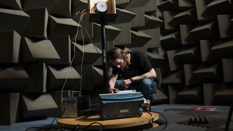 Student working on equipment in the anechoic chamber, Newton Building, University of Salford