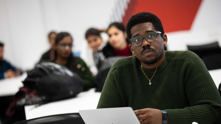 SBS male student looking past camera in class