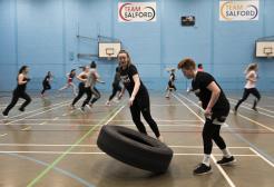 Students exercising in the University of Salford Sports Centre sports hall