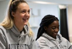 Two sports science students smiling during a lecture