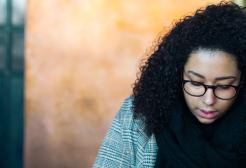 Woman sat in a restaurant looking downwards