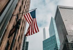 Low-angle photo of New York skyscrapers and American flag