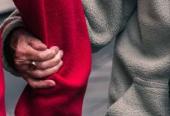 Elderly hand holding the arm of another person