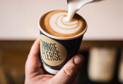 Pouring milk into a coffee Change Please branded cup