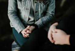 Seated people with folded hands
