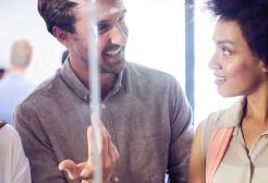 Three colleagues in conversation together in a bright, modern workspace
