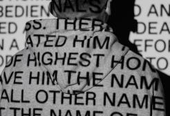 Projected words on the back of a man wearing a hoodie