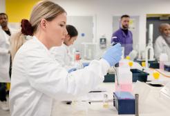 Chemistry student using a pipette in a laboratory