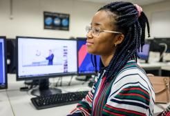A student sitting beside a computer