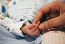 Person holding baby's hand