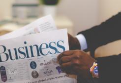A person reads a business newspaper
