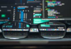 Reading glasses with a computer screen in the background