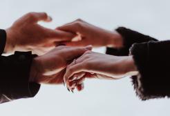 Two people's hands close up reaching out to each other